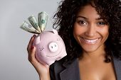 stock photo of currency  - African american woman holding piggy bank - JPG 