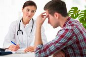 image of males  - doctor talking to her male patient at office - JPG 