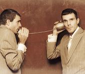 pic of communication  - Vintage Photograph Of Two Business People Exchanging Information Down The Line Of A Tin Can Telephone In A Retro Communication Conceptual - JPG 