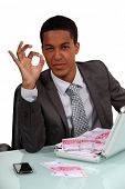 picture of money  - businessman holding a briefcase full with money and making an okay sign - JPG 