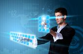 stock photo of future technology  - Man pressing modern touch screen buttons with a blue technology background - JPG 