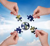 picture of globe  - Business concept with a hand building puzzle globe - JPG 