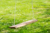 stock photo of teeter  - An empty wooden swing in the garden in summer
 - JPG 