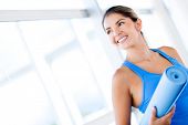 stock photo of fitness  - Beautiful woman with a yoga mat at the gym - JPG 