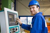 stock photo of construction worker  - Construction worker operating a large machine with a control panel - JPG 
