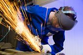 stock photo of construction  - A construction worker using an angle grinder producing a lot of sparks - JPG 