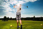 picture of golf  - Young golf player on course doing golf swing - JPG 