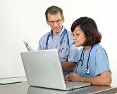 pic of medical doctors  - Doctor and nurse reviewing patient information on laptop computer - JPG 