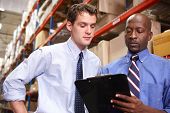stock photo of businessmen  - Two Businessmen With Clipboard In Warehouse - JPG 
