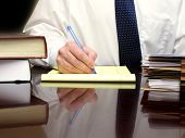 image of handshake  - Business Man sitting at desk holding pen with files - JPG 