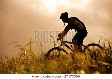 Picture or Photo of Healthy fit man rides his mountainbike outdoors, carefree bicycle fitness