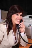 image of receptionist  - Beautiful brunette receptionist talking on the telephone - JPG 