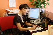 stock photo of receptionist  - a woman receptionist working hard at the front desk - JPG 