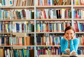 picture of reading  - Portrait of clever student with open book reading it in college library - JPG 