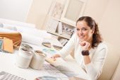 image of interior  - Young female interior designer at office with paint and color swatch - JPG 