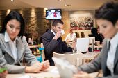 stock photo of newspaper  - Businessman sitting alone in a cafe  with a coffee and reading the newspaper - JPG 