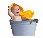 picture of youngster  - Merry little baby laughing in excitement as it plays with a bright yellow towel while sitting in a zinc bath tub - JPG 