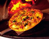 picture of restaurant  - Gourmet Pizza coming out of wood fired Pizza Oven in restaurant - JPG 