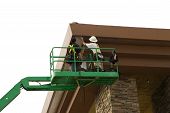 picture of construction worker  - two men in a bucket platform working on building from cherry picker - JPG 