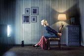 pic of interior  - Young  woman sitting on a chair in vintage interior  and watching retro tv - JPG 