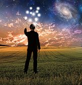 stock photo of surreal  - Man in suit conceptualizes touches sky creating ripples - JPG 