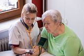 stock photo of pressure  - nurse makes home visits and measured blood pressure - JPG 