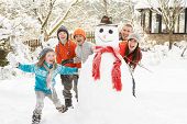 pic of wrapped  - Family Building Snowman In Garden - JPG 