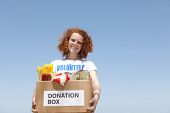 foto of food  - happy volunteer carrying food donation box smiling - JPG 