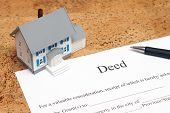 stock photo of investment  - A scale house on some forms for a deed to conceptualize on the financial investment - JPG 