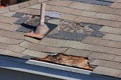 foto of outdoor  - A close up view of shingles being blown off a roof and other roof damage - JPG 