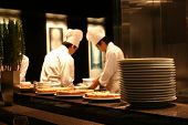 picture of restaurant  - two chefs working in a busy restaurant kitchen with tasty food cooling in the foregound - JPG 