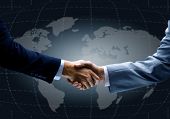stock photo of meeting  - Handshake with map of the world in background - JPG 
