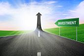 image of investment  - A road turning into an arrow rising upward with a road sign of investment symbolizing the road to improve investment - JPG 