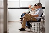 stock photo of people  - Row of multiethnic people sitting side by side while waiting for doctor in hospital lobby - JPG 