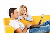 stock photo of computer  - Happy young man and woman sitting together and looking at computer screen - JPG 