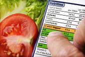 pic of food  - Reading a nutrition label on food packaging with fresh salad background - JPG 