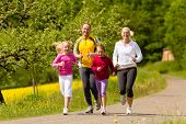 image of fitness  - Happy Family with two girls running or jogging for sport and better fitness in a meadow in summer - JPG 