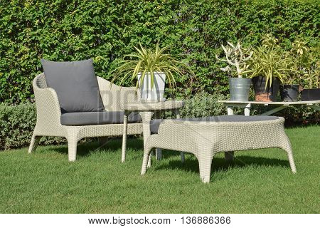 Green Garden With An Outdoor Furniture Lounge Group With Rattan Chairs, Sofa And Table