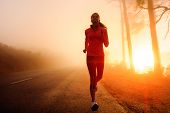 foto of fitness  - Healthy running runner woman early morning sunrise workout on misty mountain road workout jog - JPG 