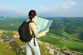 stock photo of map  - Girl tourist in mountain read the map - JPG 