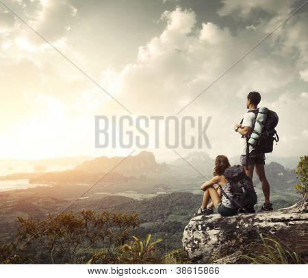 Picture or Photo of Hikers with backpacks enjoying valley view from top of a mountain