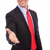 stock photo of handshake  - business man with an open hand ready to seal a deal with a handshake - JPG 