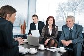 picture of feedback  - Businesswoman in an interview with three business people getting positive feedback - JPG 