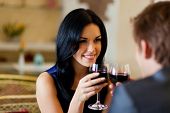 picture of meeting  - Young happy couple romantic date drink glass of red wine at restaurant, celebrating valentine day
** Note: Shallow depth of field - JPG 