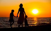 picture of beach  - Mother and her kids silhouettes on beach at sunset - JPG 