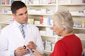 stock photo of thirties  - American pharmacist with senior woman in pharmacy - JPG 