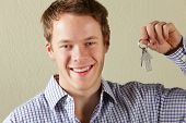 image of home  - Studio Shot Of Young Man Holding Keys To First Home - JPG 