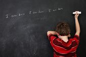 foto of spell  - Boy with poor spelling and low self esteem writing on a blackboard - JPG 