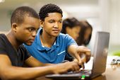 stock photo of notebook  - african college students using laptop together - JPG 
