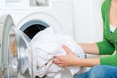 picture of home  - Young woman or housekeeper has a laundry day at home - JPG 